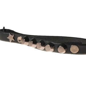 May include: A black leather wristband with silver studs and a star charm.
