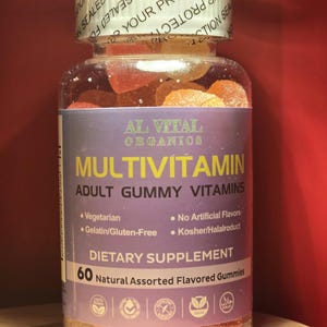 Puede incluir: Una botella de pl&aacute;stico transparente llena de vitaminas gomosas variadas. La etiqueta dice "AL VITAL ORGANICS MULTIVITAMIN ADULT GUMMY VITAMINS". La botella contiene 60 gomitas naturales con sabores variados. La etiqueta tambi&eacute;n indica que las gomitas son vegetarianas, sin gelatina/gluten y kosher/halal.