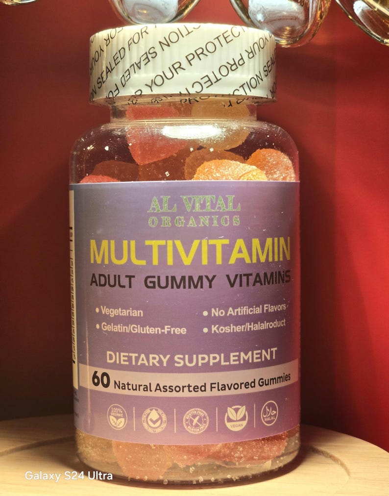 Puede incluir: Una botella de pl&aacute;stico transparente llena de vitaminas gomosas variadas. La etiqueta dice "AL VITAL ORGANICS MULTIVITAMIN ADULT GUMMY VITAMINS". La botella contiene 60 gomitas naturales con sabores variados. La etiqueta tambi&eacute;n indica que las gomitas son vegetarianas, sin gelatina/gluten y kosher/halal.