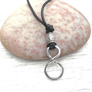 Minimalist silver infinity loop eyeglass holder on adjustable black cord