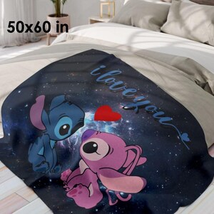 May include: A dark blue throw blanket with a space-themed design featuring two cartoon characters, a red heart, and the words "i love you." The blanket measures 50 x 60 inches.