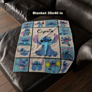 May include: A blue and white blanket featuring the character Stitch from Lilo & Stitch. The blanket is 30 x 40 inches and has a grid pattern with various images of Stitch. The name "Eupsia" is written on the blanket.