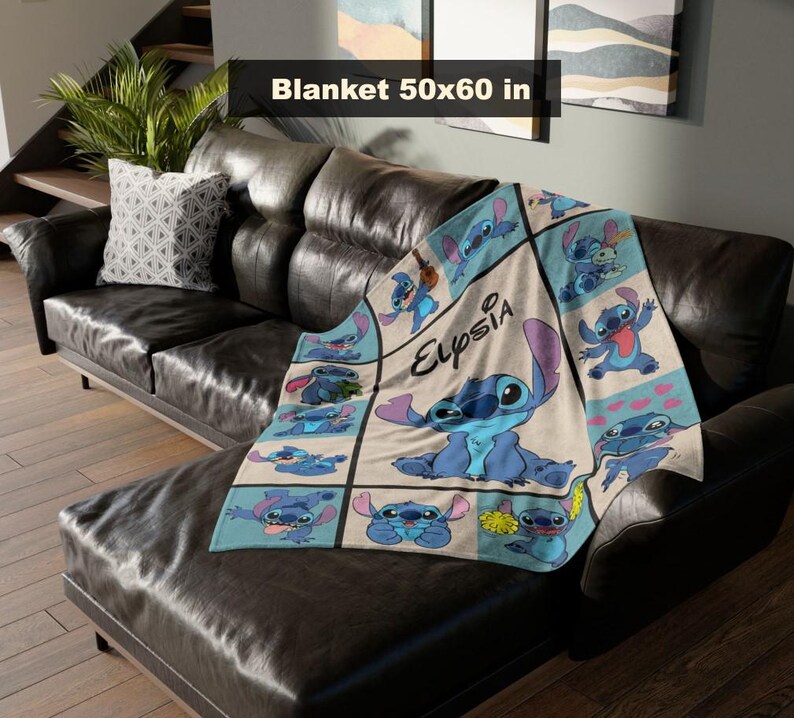 May include: A beige and blue blanket featuring the character Stitch from Lilo & Stitch. The blanket is 50x60 inches and has a grid pattern with various images of Stitch. The name "Elysia" is also printed on the blanket.