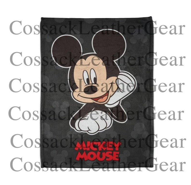 May include: A black blanket with a large illustration of Mickey Mouse waving. The blanket has a dark grey background with a subtle polka dot pattern and the words "Mickey Mouse" in red.