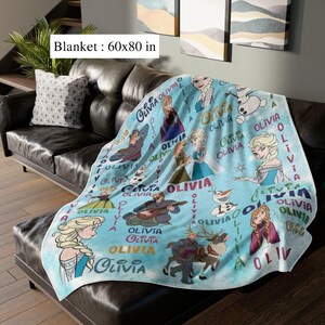 May include: A light blue blanket featuring characters from a popular animated film, with the name "Olivia" repeated throughout. The blanket measures 152 x 203 cm.