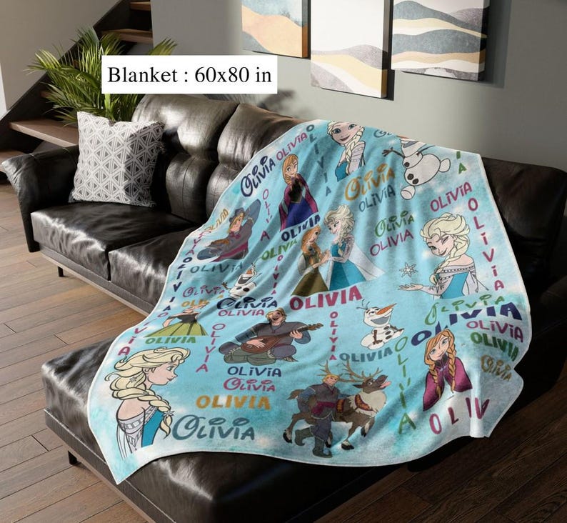 May include: A light blue blanket featuring characters from a popular animated film, with the name "Olivia" repeated throughout. The blanket measures 152 x 203 cm.