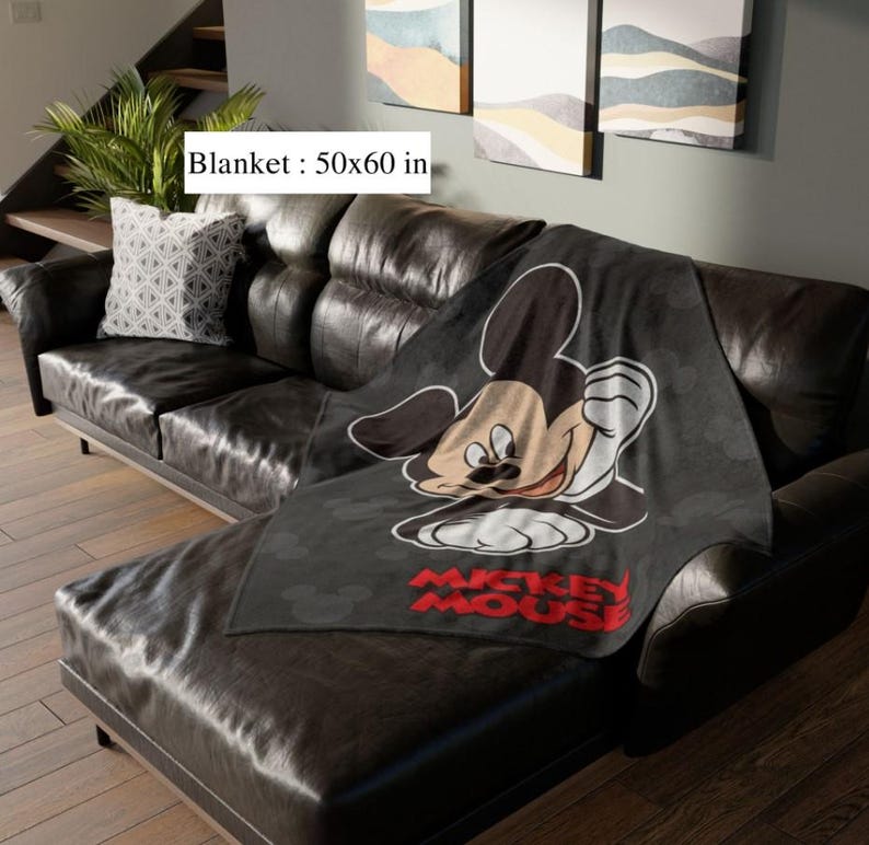 May include: A black blanket, 127x152 cm, with a large Mickey Mouse graphic. The blanket has a repeating pattern of Mickey Mouse silhouettes and the words "Mickey Mouse" in red.