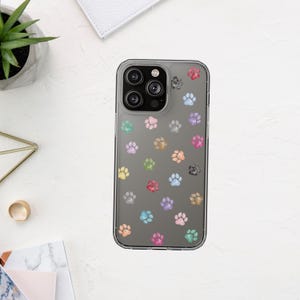 Op de afbeelding: Transparante telefoonhoes met een patroon van kleurrijke pootafdrukken. De pootafdrukken zijn in verschillende kleuren, waaronder roze, blauw, groen en geel. De hoes is ontworpen voor een smartphone.
