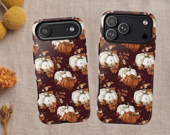 Könnte beinhalten: Zwei Handyhüllen mit einem herbstlichen Design. Die Hüllen haben einen dunkelroten Hintergrund mit einem Muster aus weißen und orangefarbenen Kürbissen sowie Herbstblättern. Die Hüllen sind für verschiedene Telefonmodelle konzipiert.