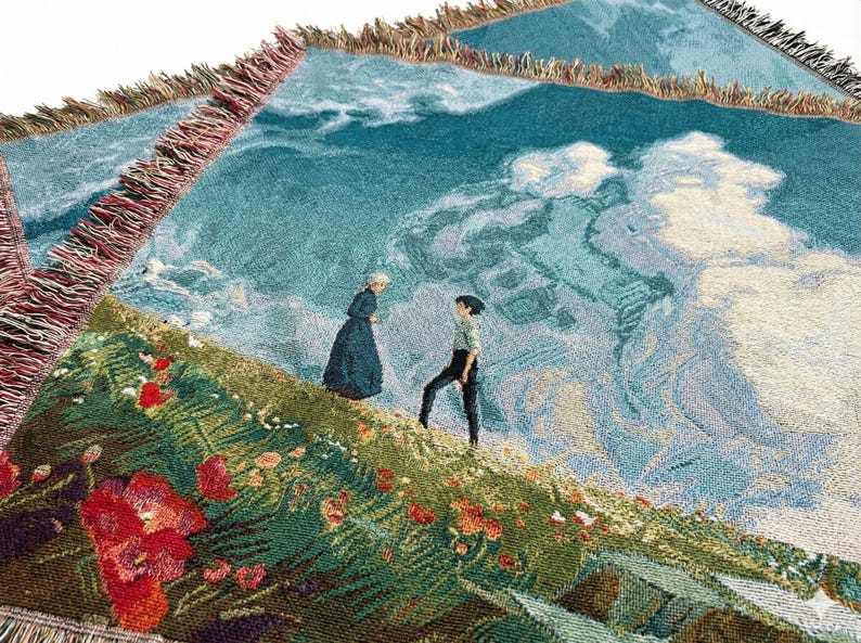 May include: Woven throw blanket featuring a landscape scene with figures on a hillside with red flowers. The background depicts a cloudy sky and a body of water. The blanket has a fringed edge.