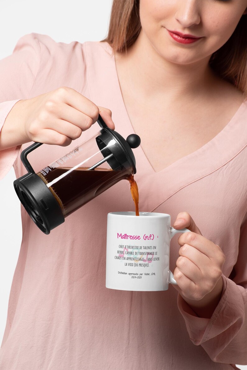 Pode incluir: Uma prensa francesa despeja caf&eacute; em uma caneca branca. A caneca tem texto em franc&ecirc;s que diz "Ma&icirc;tresse (nf.)" e uma defini&ccedil;&atilde;o. A prensa francesa &eacute; preta e de vidro. O caf&eacute; &eacute; marrom escuro.