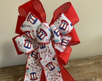 Patriotic wreath bow a red white and blue top hats and fireworks ribbon and solid red linen ribbon