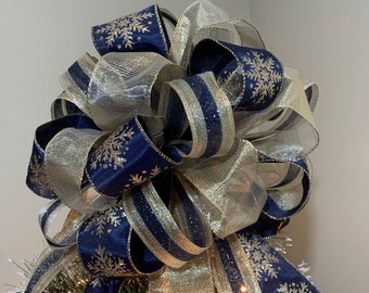 Large Christmas Tree Topper Bow Navy blue with champagne gold snowflakes, a champagne gold sheer ribbon and a gold and navy stripe ribbon