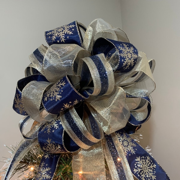 Grand nœud pour décoration de sapin de Noël Bleu marine avec flocons de neige champagne dorés, un ruban transparent champagne doré et un ruban à rayures dorées et bleu marine