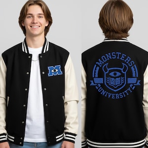 Może przedstawiać: Czarna i kremowa kurtka typu varsity z logo Monsters University z przodu i z tyłu. Z przodu znajduje się niebieskie logo "M", a z tyłu okrągła odznaka z napisem "Monsters University".