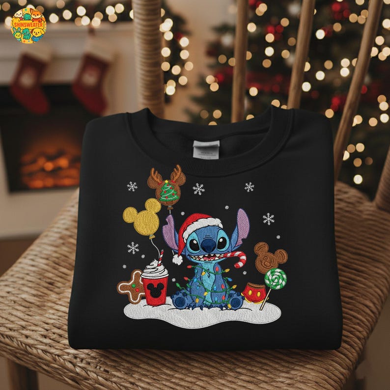 K&ouml;nnte beinhalten: Schwarzes Sweatshirt mit einem festlichen Stitch-Design. Stitch tr&auml;gt einen Weihnachtsmannhut und ist von Weihnachtslichtern, Schneeflocken und festlichen Leckereien umgeben. Das Design umfasst einen Lebkuchenmann, Mickey Mouse-Ballons und eine Zuckerstange.
