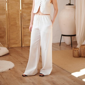 Puede incluir: Conjunto de dos piezas de lino blanco. El conjunto incluye un chaleco sin mangas con botones y pantalones de pernera ancha con cintura con cordón. El conjunto está hecho de una tela ligera, perfecto para climas cálidos.