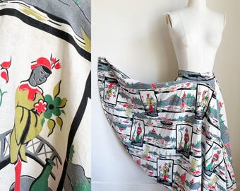 May include: A white cotton skirt with a colorful print of Asian-inspired figures and boats. The skirt is full and has a gathered waist.