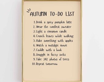 May include: A framed print with the text "Autumn To-Do List" in black. The list includes activities like drinking a pumpkin spice latte, wearing a sweater, and baking with apples. The frame is gold.