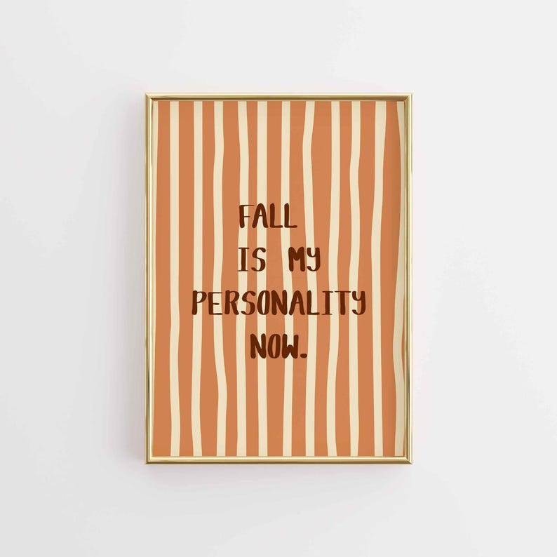 Peut inclure: Une affiche encadr&eacute;e avec un cadre dor&eacute;. L'&oelig;uvre pr&eacute;sente un fond de rayures verticales orange avec des rayures cr&egrave;me. Le texte "FALL IS MY PERSONALITY NOW" est en lettres marron.