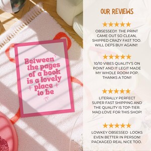 May include: A pink framed print with the text "Between the pages of a book is a lovely place to be." The print is on a white rug with a pink and orange design. The image also shows customer reviews.