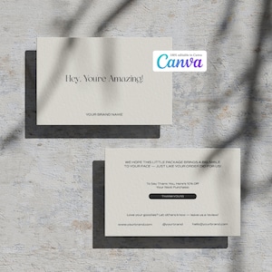 以下が含まれることがあります： テキストが書かれた2枚のクリーム色の名刺。上のカードには「Hey, You're Amazing!」と「YOUR BRAND NAME」と書かれています。下のカードには「WE HOPE THIS LITTLE PACKAGE BRINGS A BIG SMILE TO YOUR FACE - JUST LIKE YOUR ORDER DID FOR US!」と「THANKYOU」と書かれています。