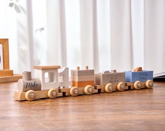 May include: A wooden toy train with a light brown engine, white number one car, and several cars in shades of beige, orange, and blue. The engine is labeled "Mike". The cars have details like birth date, weight, and length.