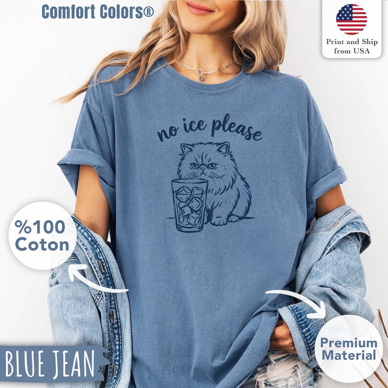 Puede incluir: Camiseta azul vaquero Comfort Colors con un gr&aacute;fico de un gato persa y un vaso de hielo, con el texto "no ice please". La camiseta es 100% algod&oacute;n.