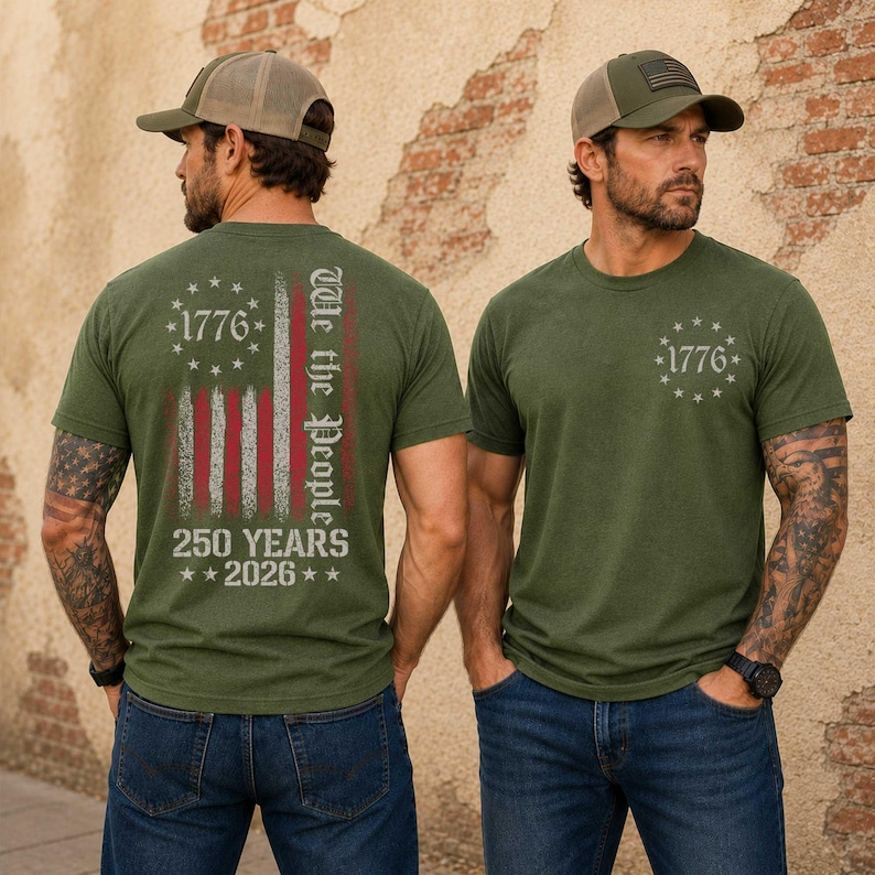 May include: Olive green t-shirts with a distressed American flag design and the text "1776" and "We the People". The back of the shirt also features "250 YEARS 2026". The models are wearing baseball caps.