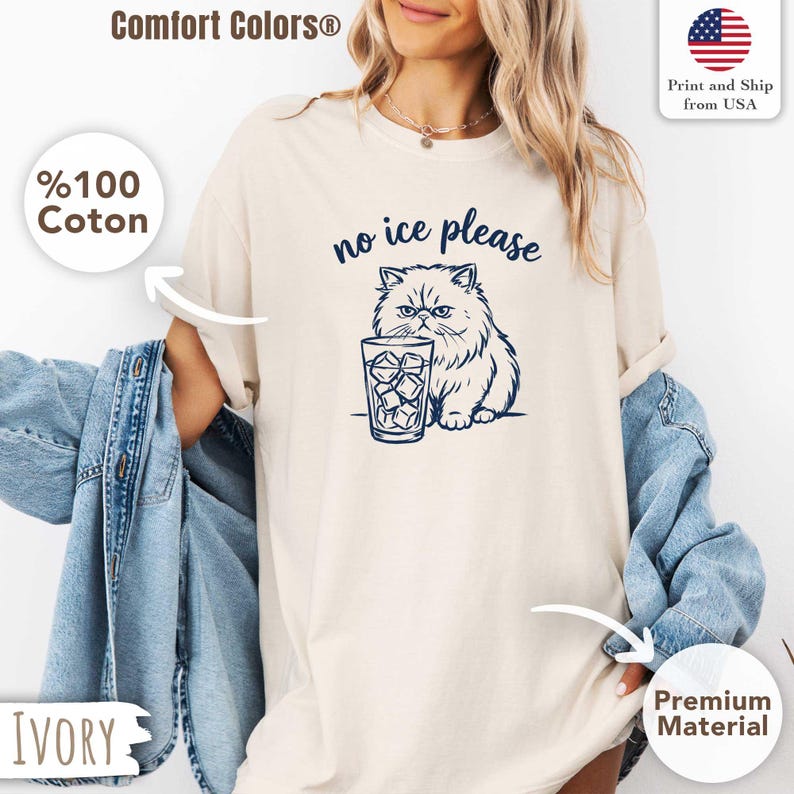 Puede incluir: Camiseta de color marfil con una ilustraci&oacute;n azul marino de un gato gru&ntilde;&oacute;n junto a un vaso de cubitos de hielo. El texto "no ice please" est&aacute; encima del gato. La camiseta est&aacute; hecha de material premium y se imprime y env&iacute;a desde EE. UU.