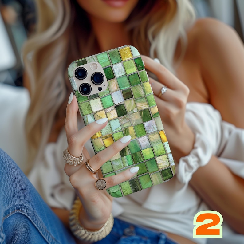 May include: Green mosaic tile phone case. The case features a pattern of small, square tiles in shades of green, yellow, and white. The phone case has a camera module with multiple lenses. The number "2" is visible in the bottom right corner.