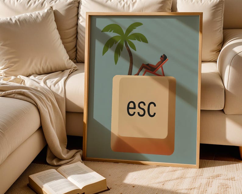 Escape key wall print in wooden frame styled on cozy beige sofa with natural sunlight and book – warm neutral home decor.