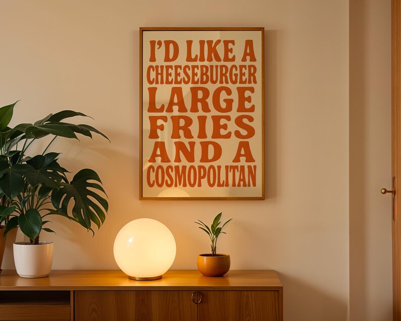 Cozy minimalist wall scene with food typography poster above wooden cabinet and round mood lamp.