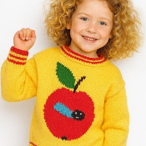 May include: A yellow knit sweater with a large red apple design, green leaf, and a blue worm. The sweater has red and yellow striped cuffs and neckline. The child is smiling and has curly blonde hair.