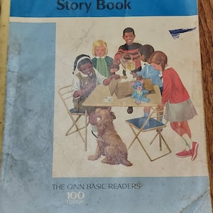 May include: A vintage children's book titled "My Little Blue Story Book" with a blue cover and a picture of children playing with a teddy bear. The book is part of "The Ginn Basic Readers 100 Edition".