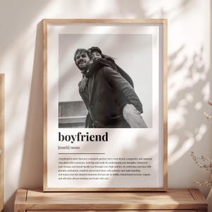 Könnte beinhalten: Ein gerahmter Schwarz-Weiß-Druck mit einem Foto eines Paares. Das Wort "boyfriend" ist in fetten, schwarzen Buchstaben unter dem Foto zusammen mit einer Definition gedruckt. Der Rahmen ist hellbraun.