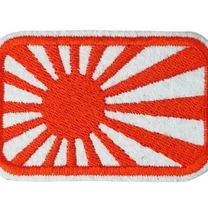 May include: Embroidered patch with a rising sun design. The patch features a red sun and rays against a white background, with a white border. The rectangular patch is suitable for application on clothing or accessories.