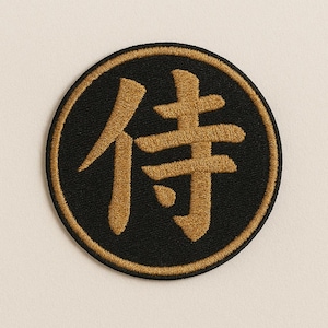 Puede incluir: Un parche redondo negro con caracteres kanji bordados en oro que se leen "侍" (Samurai).