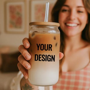 May include: A clear glass tumbler with a wooden lid and a clear straw, filled with a layered drink. The text "YOUR DESIGN" is printed on the front of the tumbler. The tumbler is held by a person.