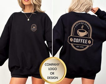 May include: Black sweatshirt with a white collar featuring a coffee shop logo on the front and back. The logo includes a coffee cup, coffee beans, and the text "COFFEE SHOP" and "COFFEE EST. 2019".
