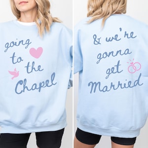 May include: Light blue sweatshirt with the text "going to the Chapel" and "& we're gonna get Married". The front of the sweatshirt has a pink heart and a dove. The back has two pink wedding rings.