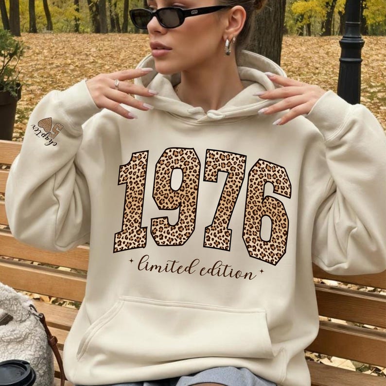 以下が含まれることがあります： 前面に大きな「1976」のヒョウ柄デザインと「limited edition」の文字が入ったクリーム色のパーカー。左袖には「Chapter」の文字がプリントされています。パーカーにはフロントポケットとフードが付いています。