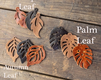 Peut inclure: Assortiment de formes de feuilles en cuir de couleur marron, noir et beige. Les feuilles sont découpées et ont un trou en haut pour être suspendues. Les feuilles sont étiquetées "Feuille tropicale", "Feuille de palmier" et "Feuille d'automne".