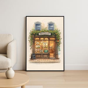 Könnte beinhalten: Ein gerahmter Aquarelldruck einer Kunstgalerie. Die Galerie hat eine Holzfassade mit den Worten "ART GALERY" über dem Eingang. Die Fenster zeigen verschiedene Gemälde, und das Gebäude ist mit grünem Laub geschmückt.