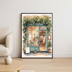 May include: Watercolor painting of a shop front with a teal door and window frames, adorned with climbing vines and pink flowers. Inside, a warm light illuminates a cozy interior with bookshelves and artwork. A framed print and potted plants are visible.