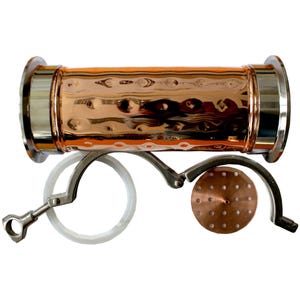 May include: A copper still component with a hammered finish, and stainless steel ends. Includes a white gasket, a perforated copper disc, and a metal clamp. The components are designed for distilling.