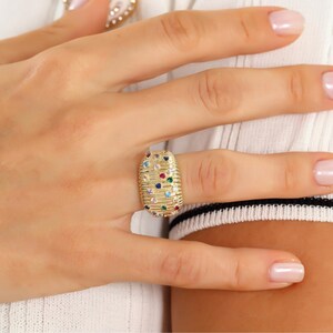 Product photograph of a wide ribbed gold dome ring.