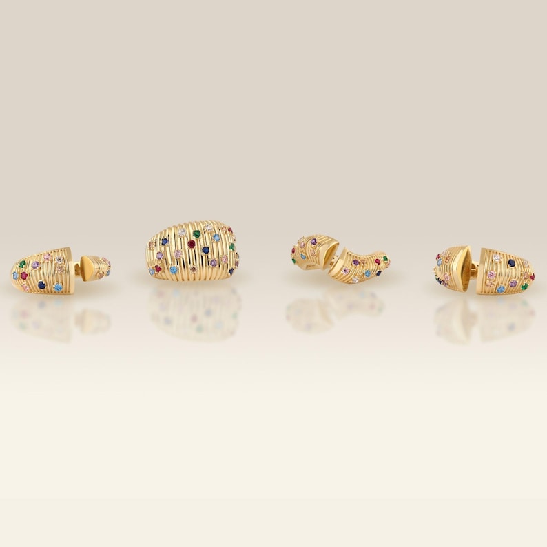Lifestyle view of the multi-color cubic zirconia fluted dome rings styled naturally on a hand against a soft-focus background.
