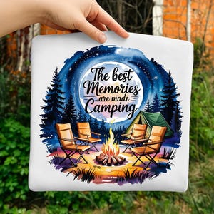 May include: White tote bag with a camping scene illustration. The design features a campfire, chairs, a tent, and a night sky with the text "The best Memories are made Camping."