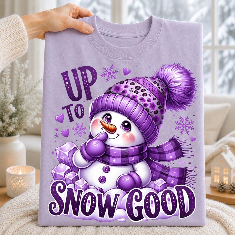 Lavender purple t-shirt featuring a cute purple snowman wearing a pom-pom hat and plaid scarf with Up to Snow Good winter artwork
